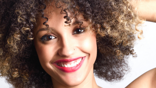 how to prevent frizzy hair: girl touching curly hair